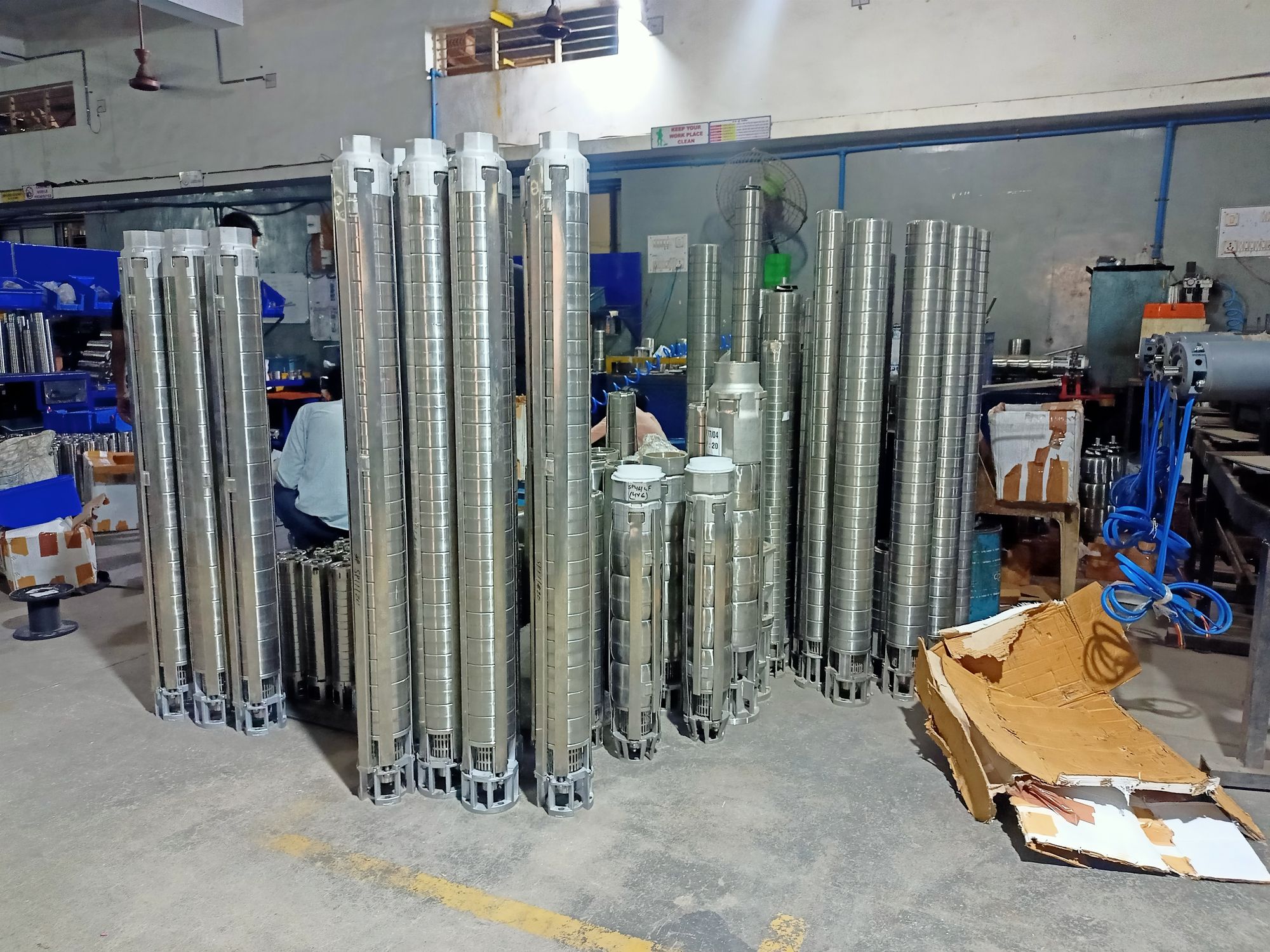 Rows of assembled stainless steel borewell pumps on the factory floor